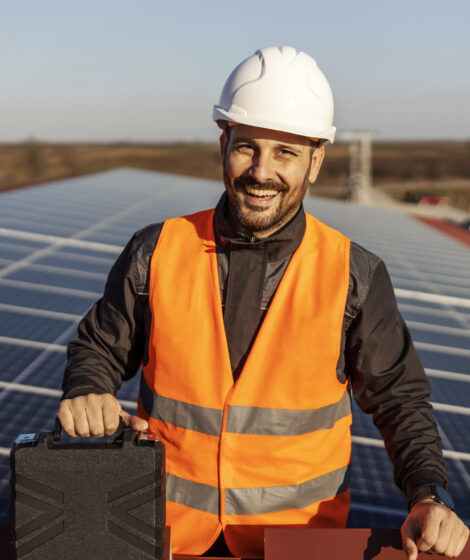 The worker is finished works with solar panels and smiling at the camera.